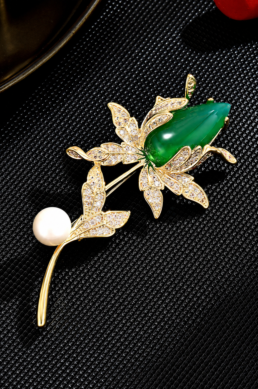 Green magnolia brooch with gold-tone detail and a white pearl