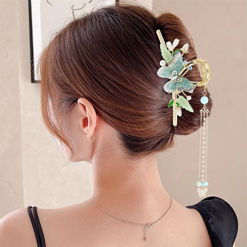 Model wearing butterfly tassel claw clip in low bun