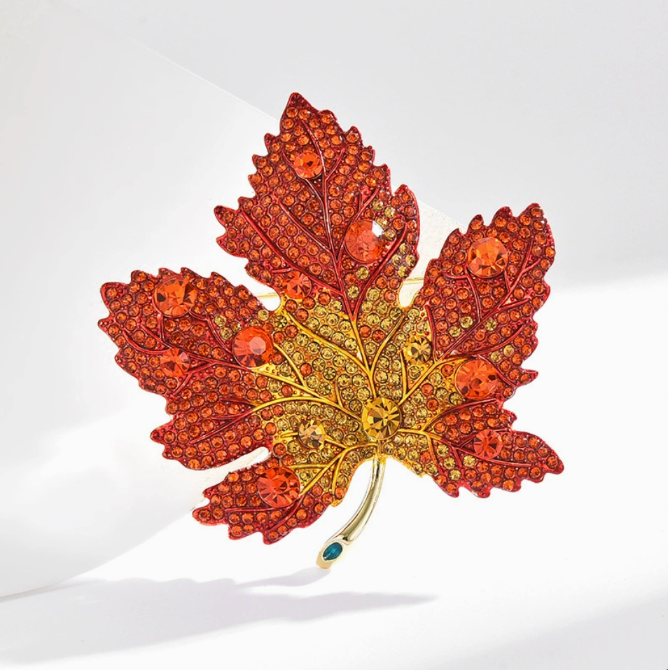 Model wearing red maple leaf crystal brooch on black blazer