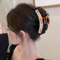 Model wearing tortoise rhinestone claw clip in updo