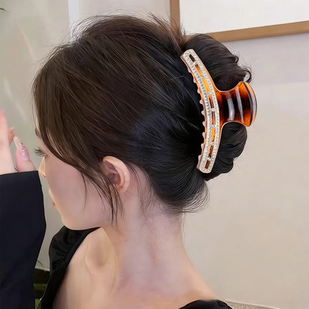 Model wearing tortoise rhinestone claw clip in updo