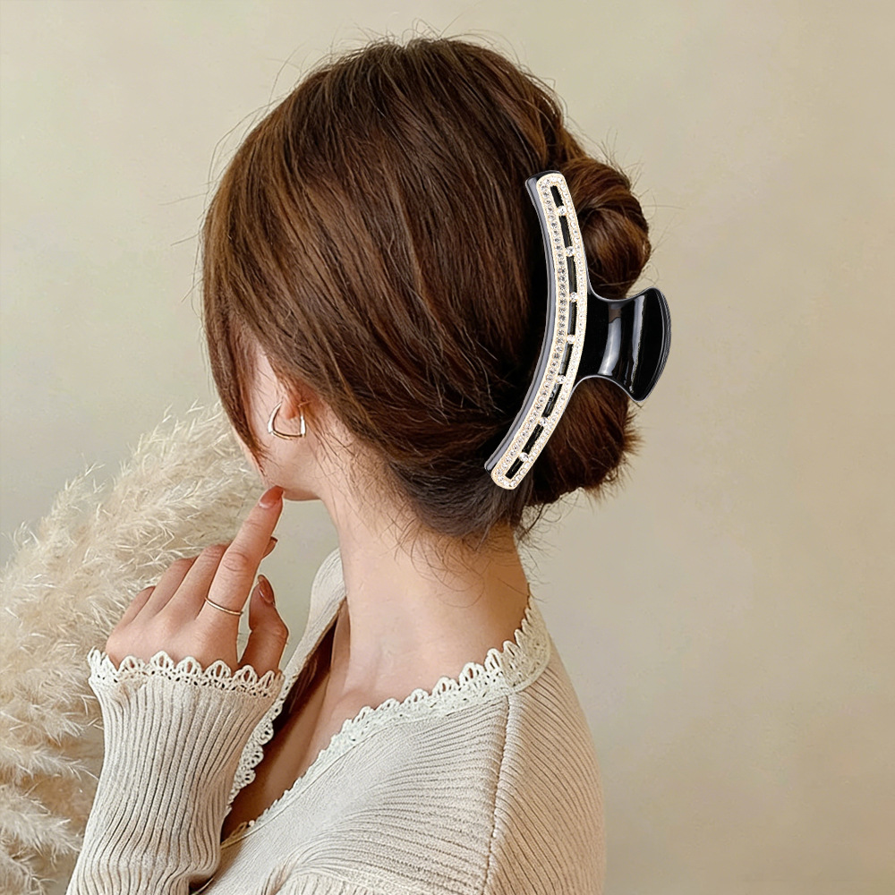 Model wearing black rhinestone claw clip in updo