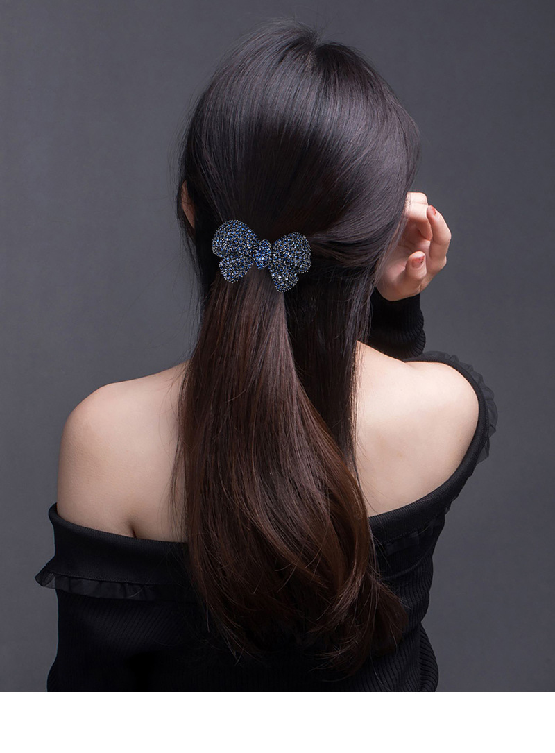 Model wearing blue rhinestone bow hair clip