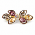 Multicolor A268 bow barrette with six mauve, champagne and smoky faceted stones on a gold-tone frame. AI-assisted supplier photo edit.