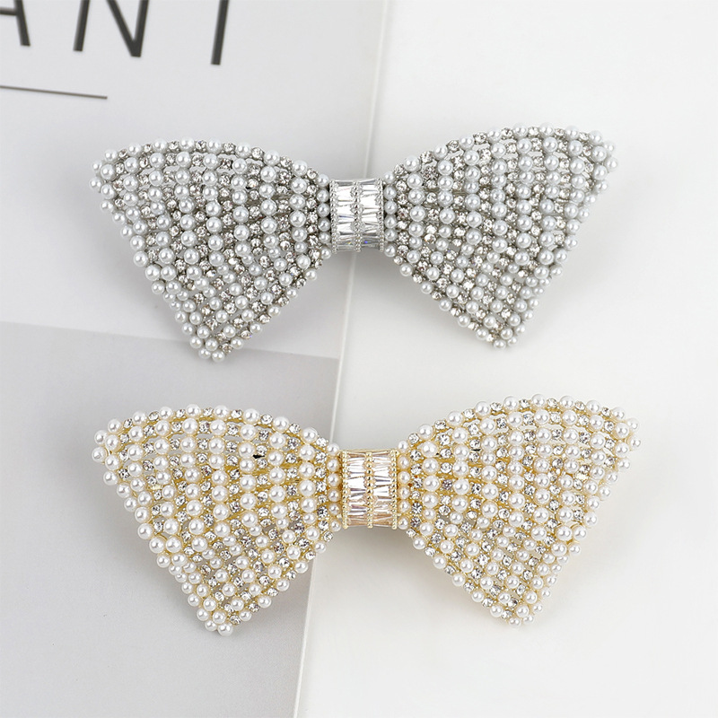 A549 bow barrettes in Silver above and Gold below, with white pearl-look beads and clear rhinestones. One barrette per order.