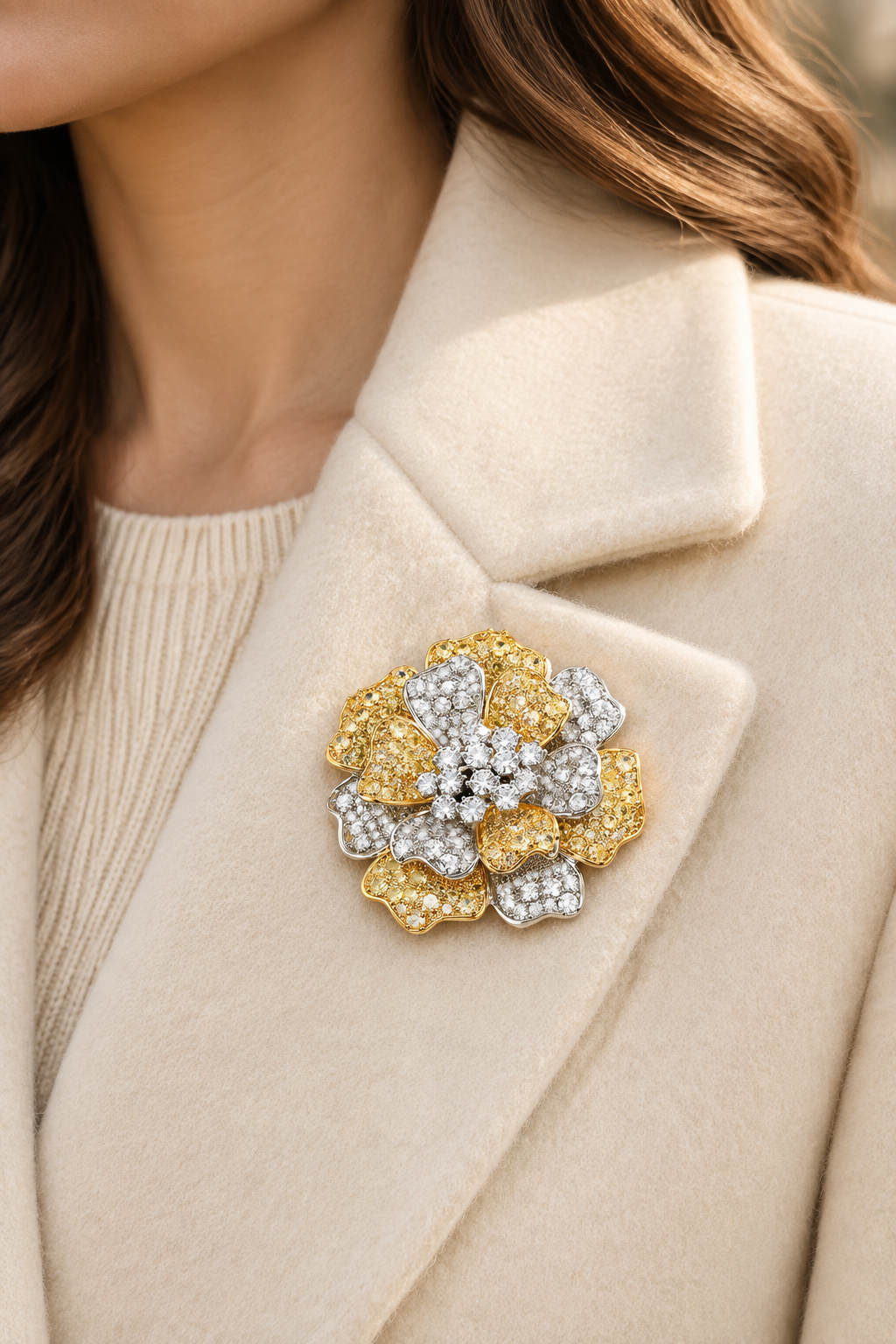 Gold and silver-tone peony brooch pinned on a cream coat lapel