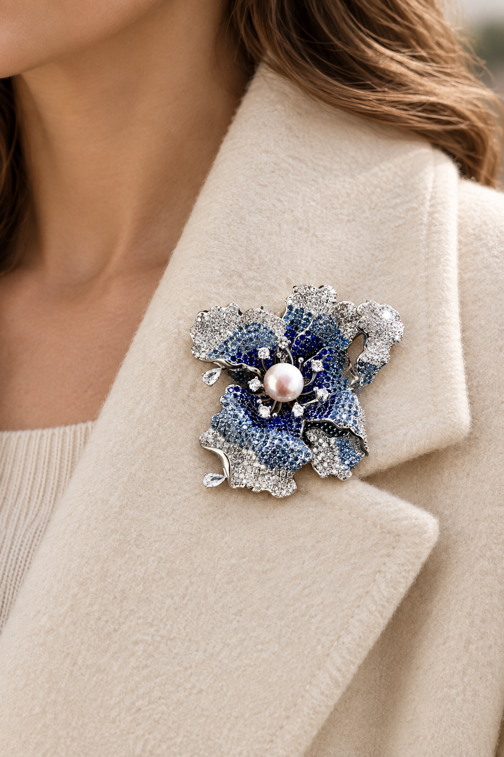 Blue iris pearl brooch pinned on a cream coat lapel