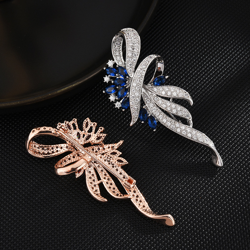 Rose-gold-tone brooch pin-back closure alongside the silver-tone blue brooch