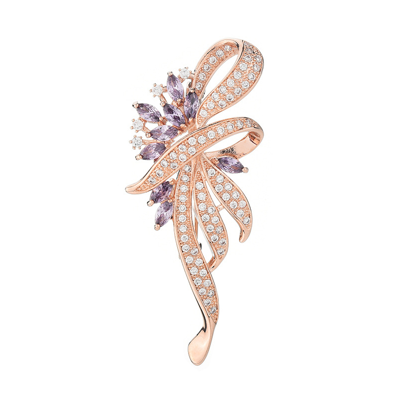 Rose-gold-tone ribbon brooch with purple and clear cubic zirconia on a white background