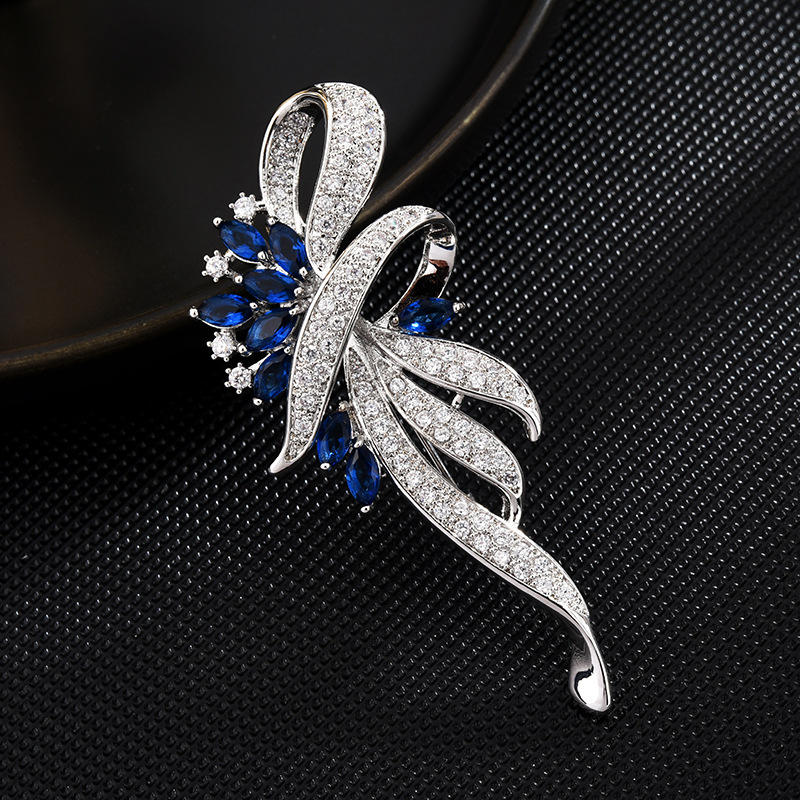 Silver-tone ribbon brooch with blue and clear cubic zirconia