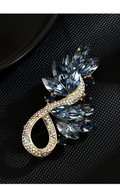Gold-tone blue crystal leaf brooch with a rhinestone loop
