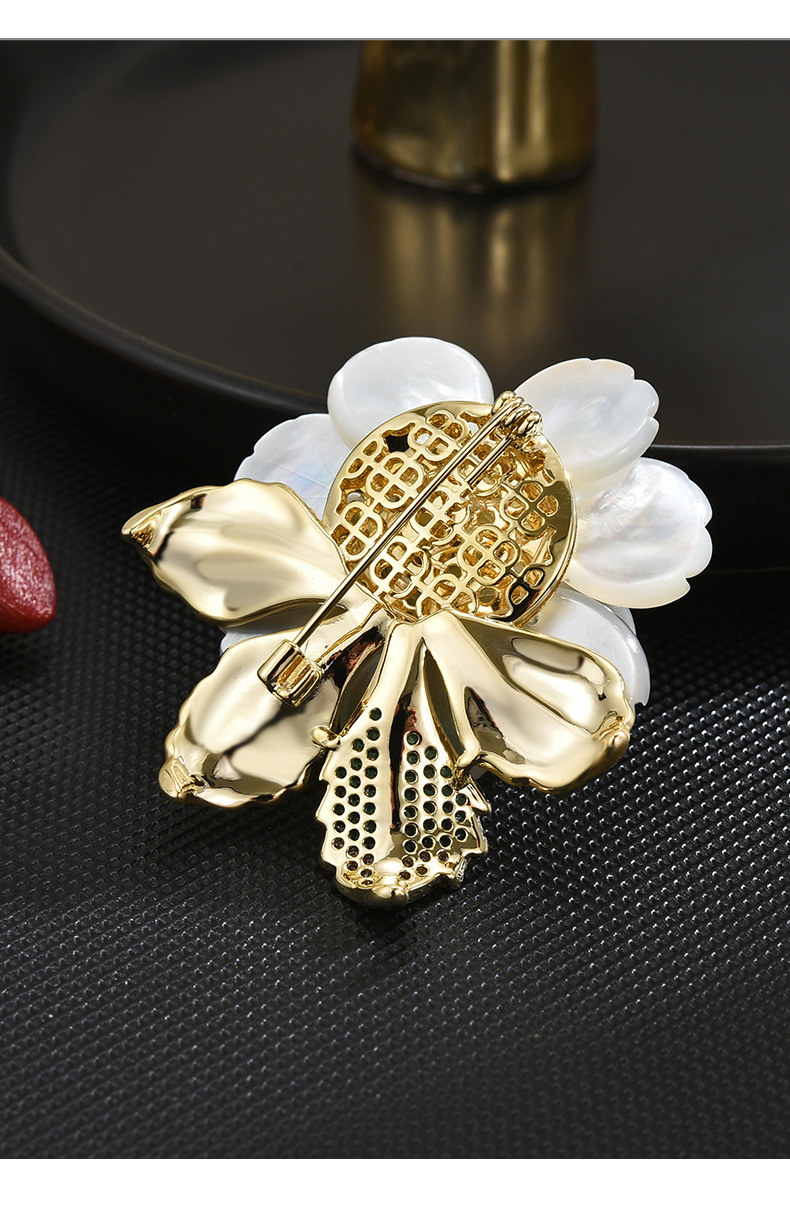 Back of the shell peony brooch showing the gold-tone openwork setting, leaves and pin fastening