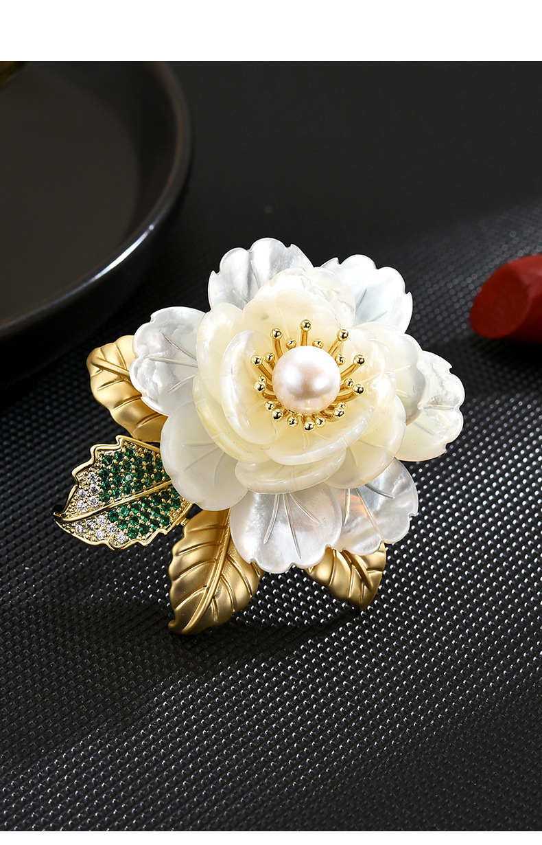 Ivory shell peony brooch with a freshwater pearl center, gold-tone leaves and a green stone-set leaf