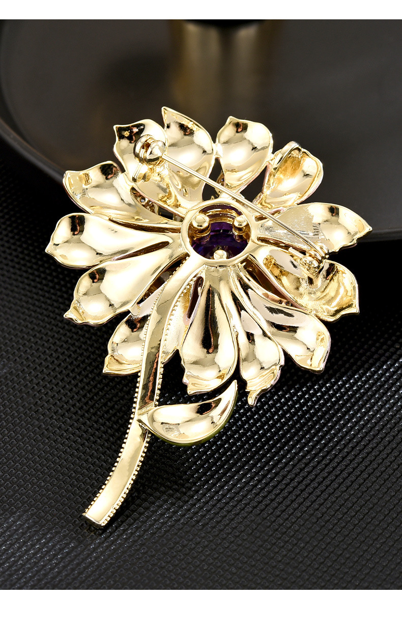 Back of the gold-tone flower brooch showing its pin and clasp