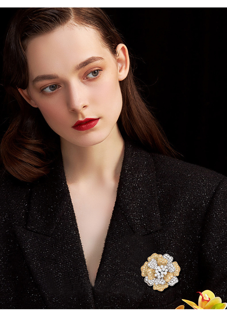 Gold-tone and silver-tone peony brooch styled on a black textured jacket
