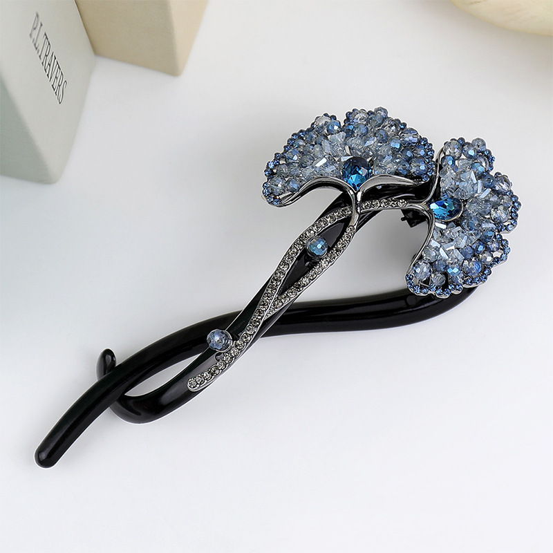 Blue ginkgo leaf twist hair clip with two fan-shaped stone-set leaves and a dark elongated frame
