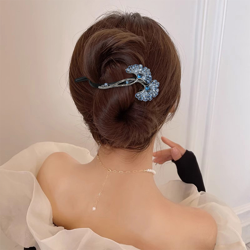 Blue ginkgo leaf twist hair clip worn across a twisted updo