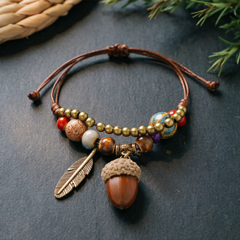 Small Acorn charm bracelet with ceramic beads, brown adjustable cord and bronze-tone feather detail