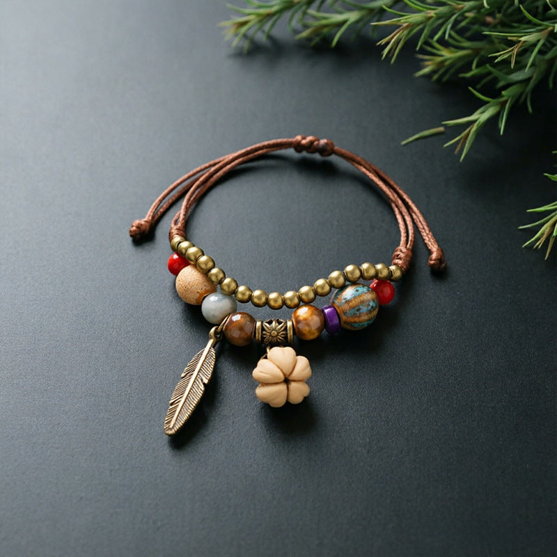 Hawthorn Seed charm bracelet with ceramic beads, brown adjustable cord and bronze-tone feather detail