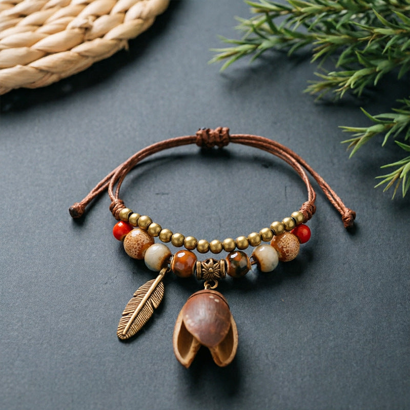 Open Brown Pod charm bracelet with ceramic beads, brown adjustable cord and bronze-tone feather detail