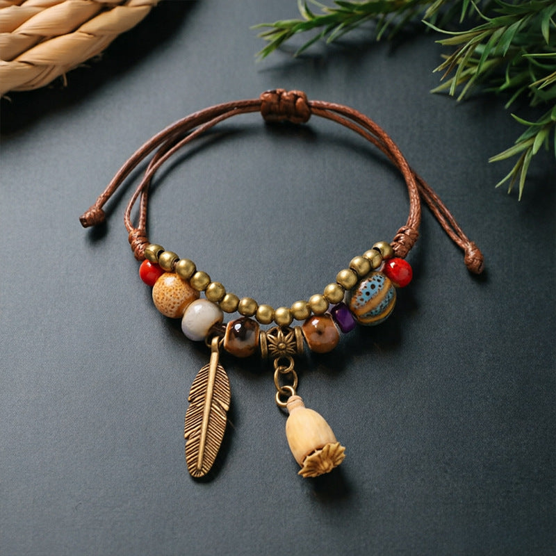Flower Capsule charm bracelet with ceramic beads, brown adjustable cord and bronze-tone feather detail