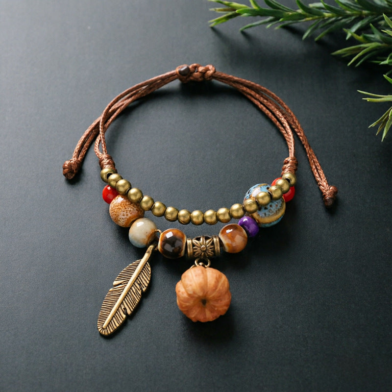 Mini Pumpkin charm bracelet with ceramic beads, brown adjustable cord and bronze-tone feather detail