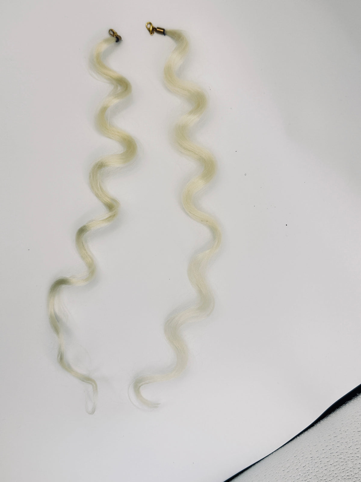 Light blonde wavy synthetic hair charm pair with gold-tone clasps; product photograph.