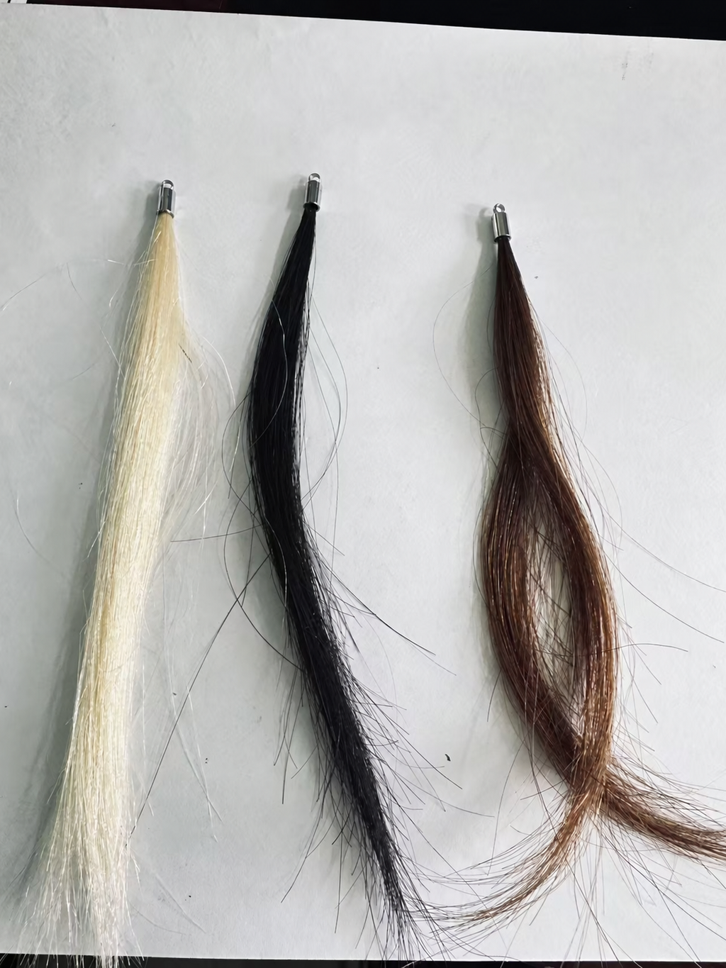 Human hair color samples: Blonde, Black and Brown, one strand per color shown; the set contains two strands per color. Silver-tone sample caps shown; full attachment kit not pictured.