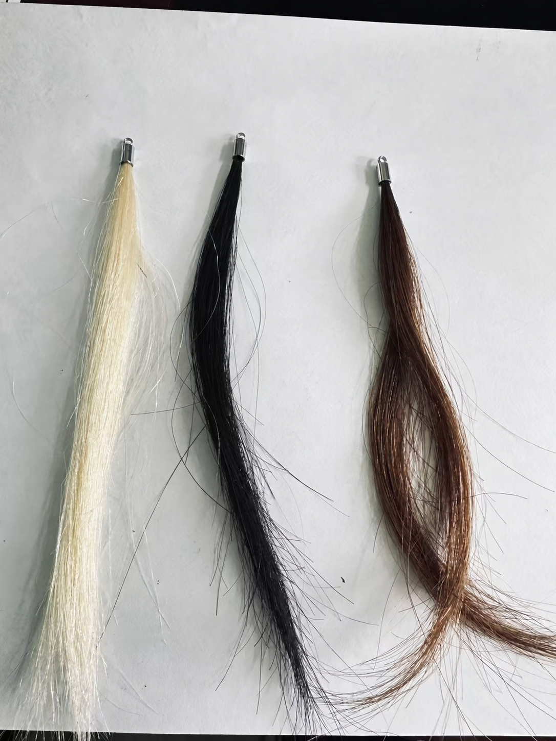 Human hair color samples: Blonde, Black and Brown, one strand per color shown; the set contains two strands per color. Silver-tone sample caps shown; full attachment kit not pictured.