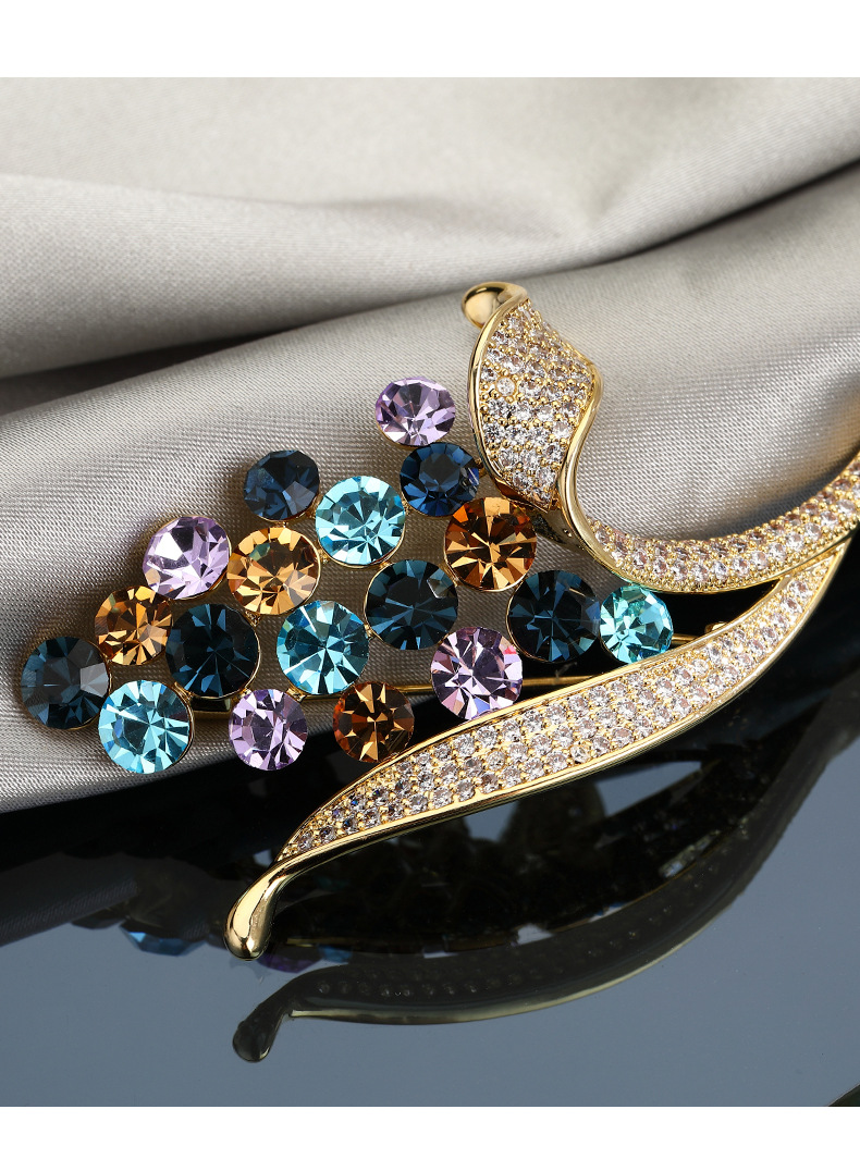 Close-up of faceted stones and clear accents on gold-tone leaves