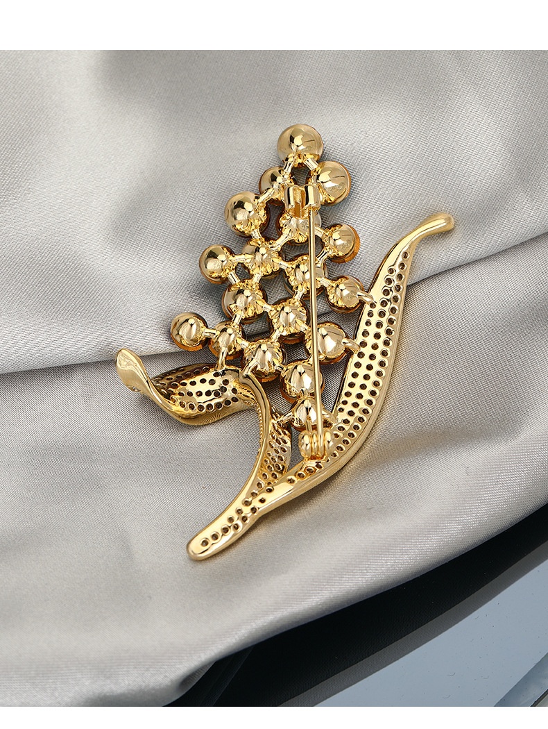 Back of the gold-tone floral brooch showing the pin and clasp