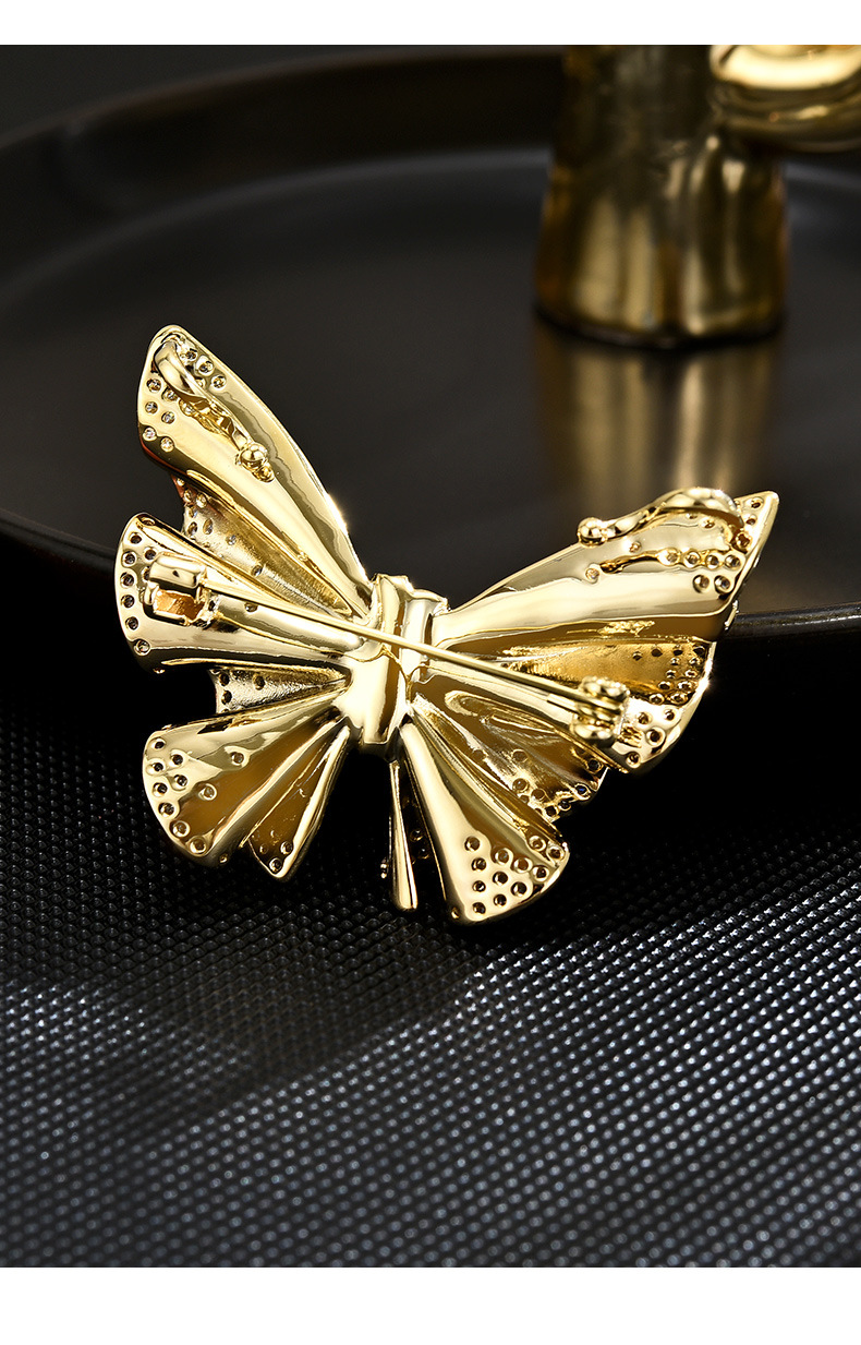Back of the gold-tone butterfly brooch showing the pin fastening and sculpted wing construction