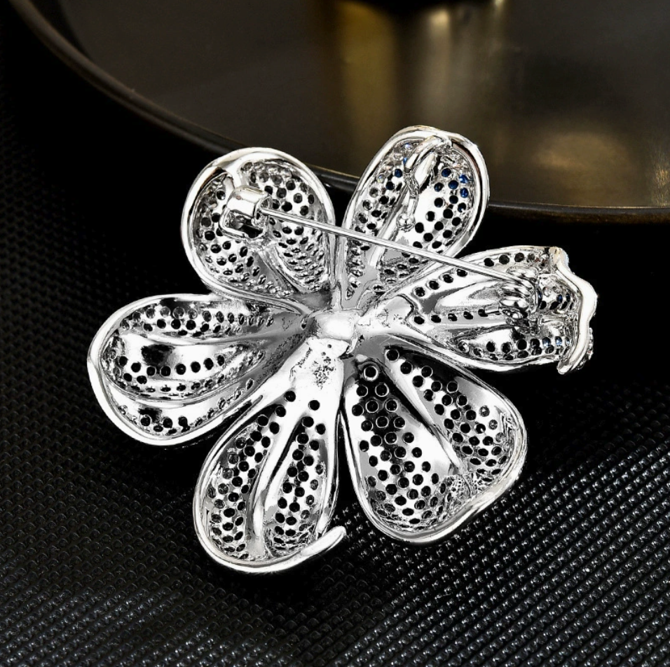 Back of the silver-tone blue lily brooch showing the pin fastening and openwork petals