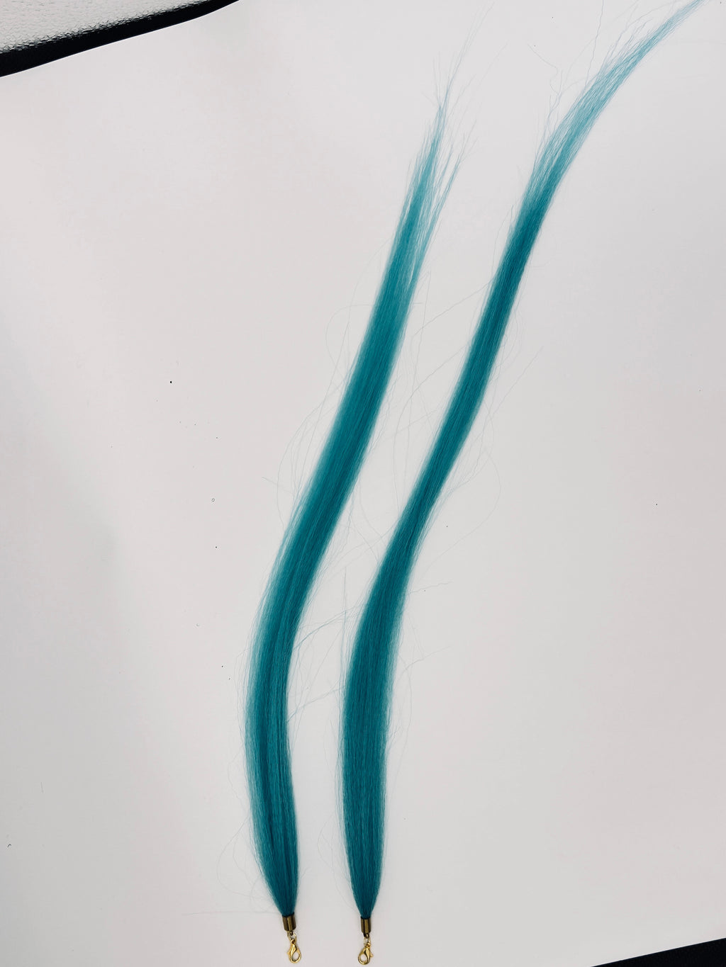 Teal straight synthetic hair charm pair with gold-tone clasps; product photograph.