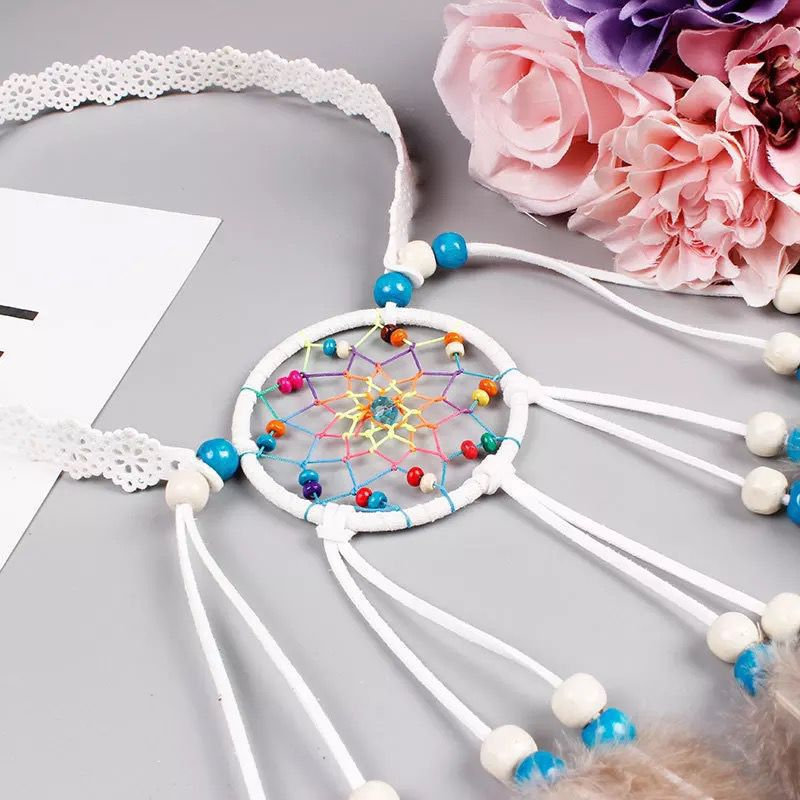 Close-up of the white headband's colorful woven circle, beads, and decorative band