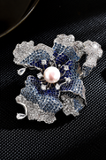 Silver-tone iris flower brooch with blue and clear decorative stones and a white freshwater pearl