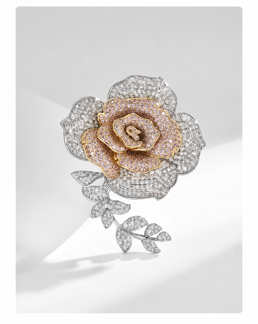 Layered silver and gold-tone cubic zirconia rose brooch displayed against a light background