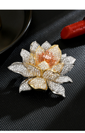 Tri-tone lotus brooch with clear cubic zirconia and shell-bead accents on a black textured surface