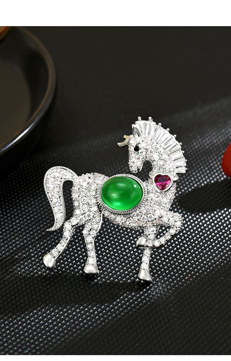 Silver-tone prancing horse brooch with a green oval accent, a pink heart accent and clear cubic zirconia