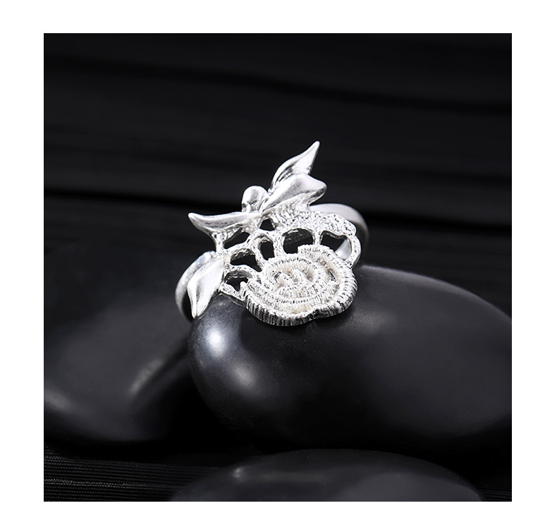 Silver-tone openwork rose ring with textured spiral petals and leaf details