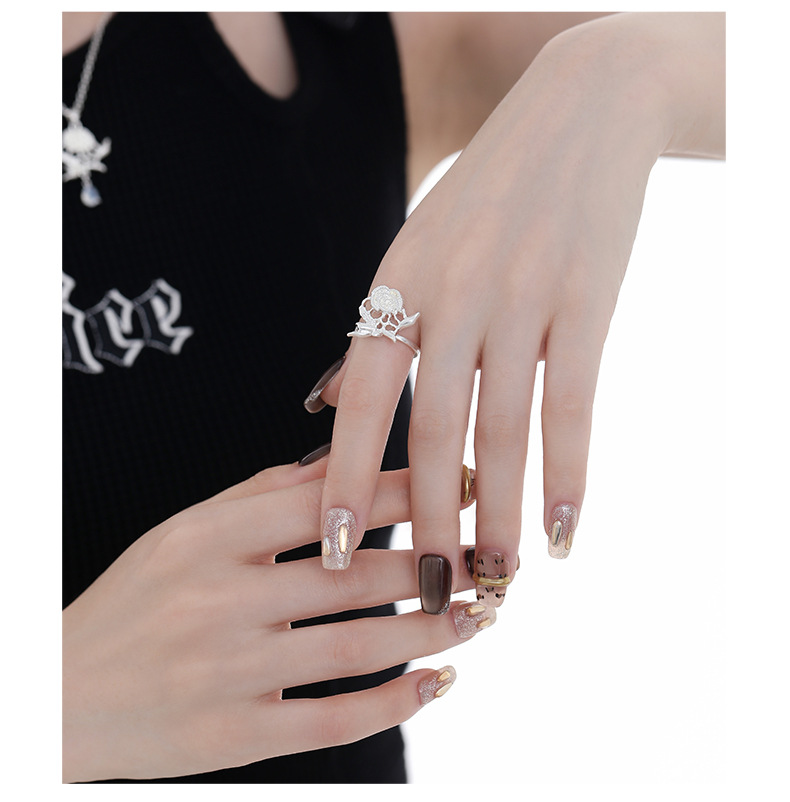 Silver-tone rose and leaf ring worn on a hand