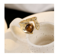 Sculptural gold-tone open ring with a brown teardrop tiger's eye centerpiece
