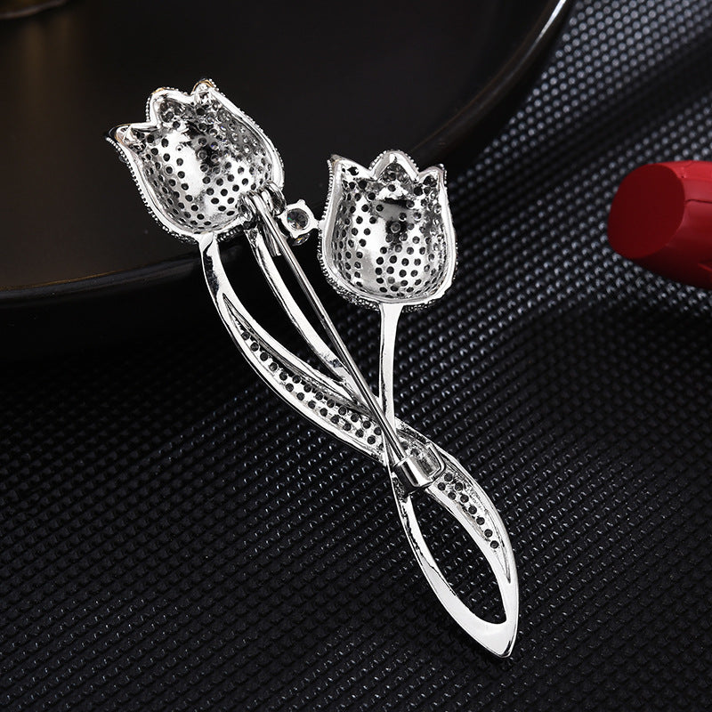 Back of the silver-tone twin tulip brooch showing the pin fastening and openwork construction