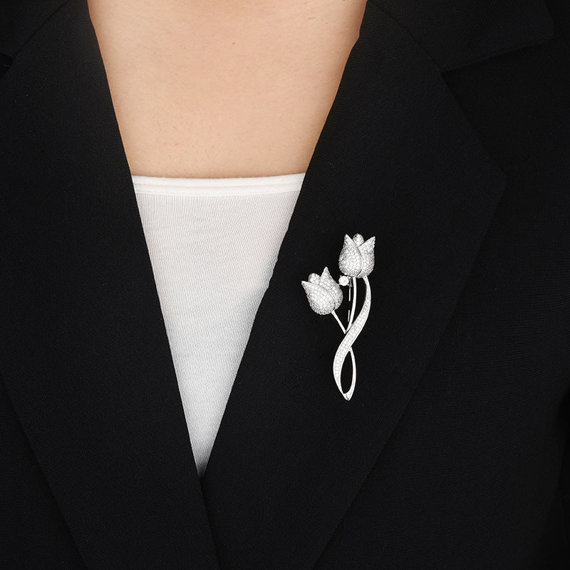 Silver-tone twin tulip brooch worn on a black blazer lapel